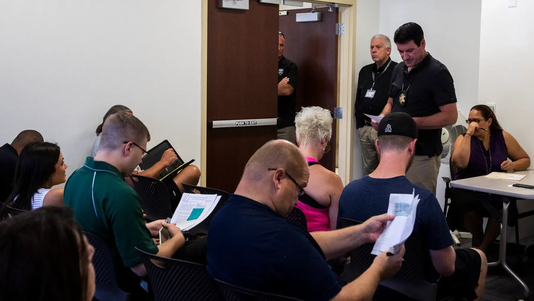 Bidders reviewing sale materials during an indoor public auction